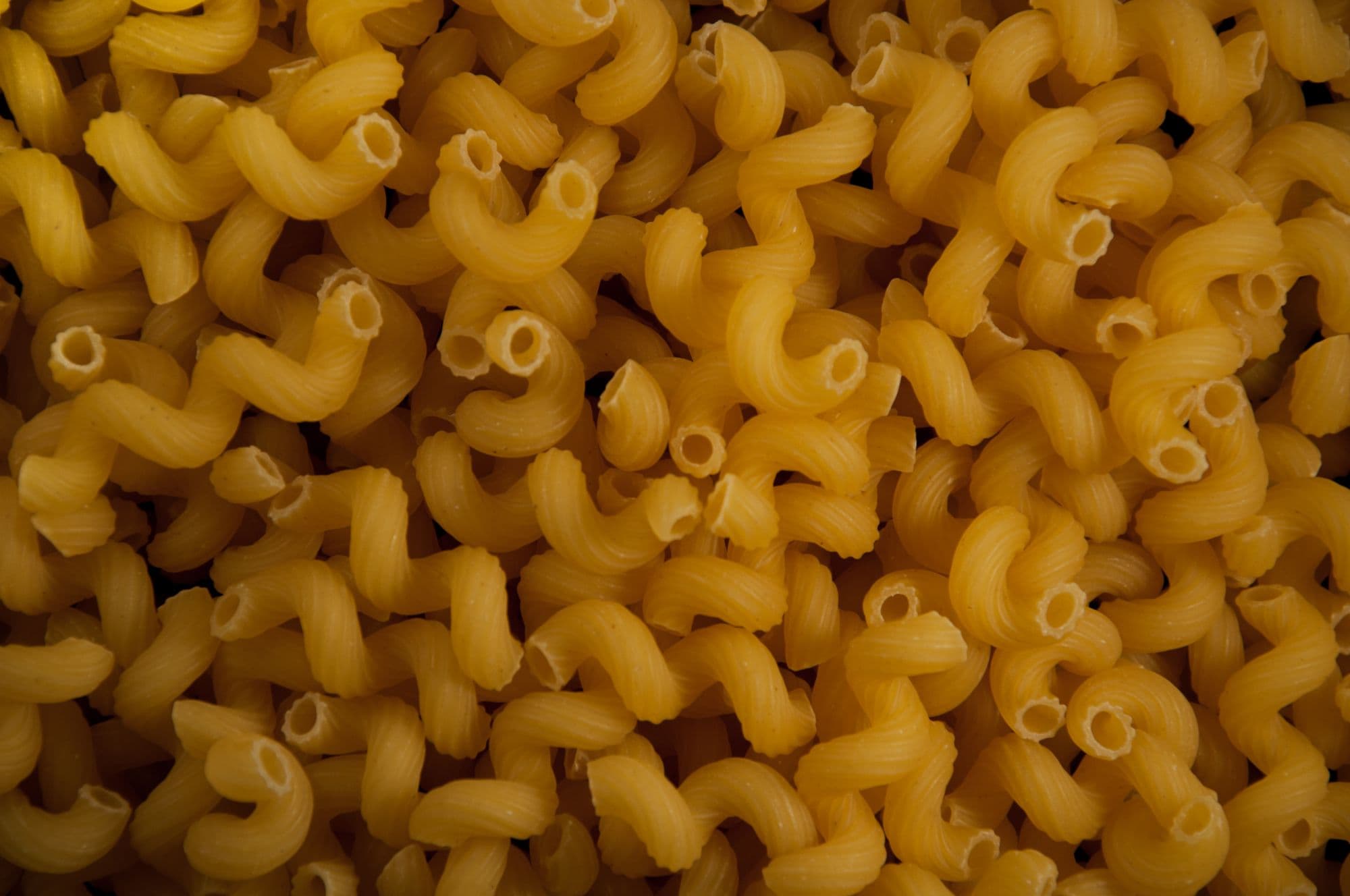 A close-up of dried cavatappi, short hollow ridged tubes coiled into corkscrews